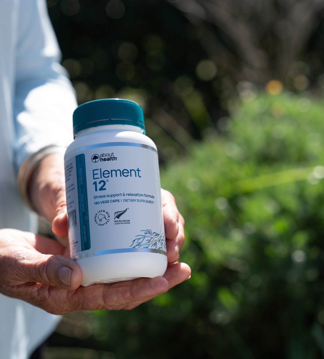 Hand holding a bottle of Element 12 Magnesium supplement for muscle support